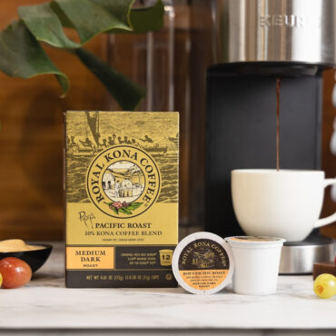 Royal Kona 10% Roy's Pacific Roast Coffee Single Serve Pods next to coffee machine