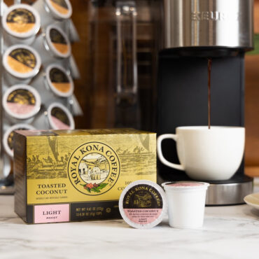 Royal Kona 10% Toasted Coconut Single Serve Pods next to coffee machine