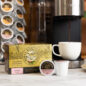 Royal Kona 10% Toasted Coconut Single Serve Pods next to coffee machine